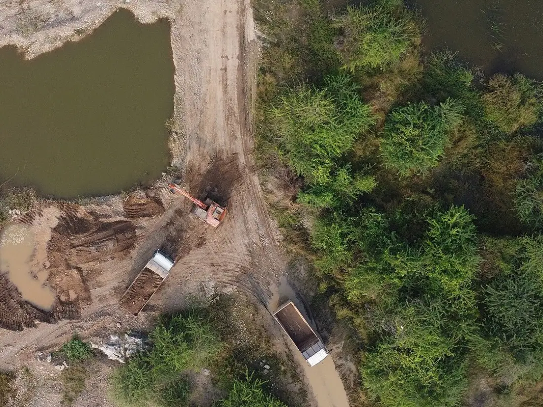 Aerial view of sand mining with tippers